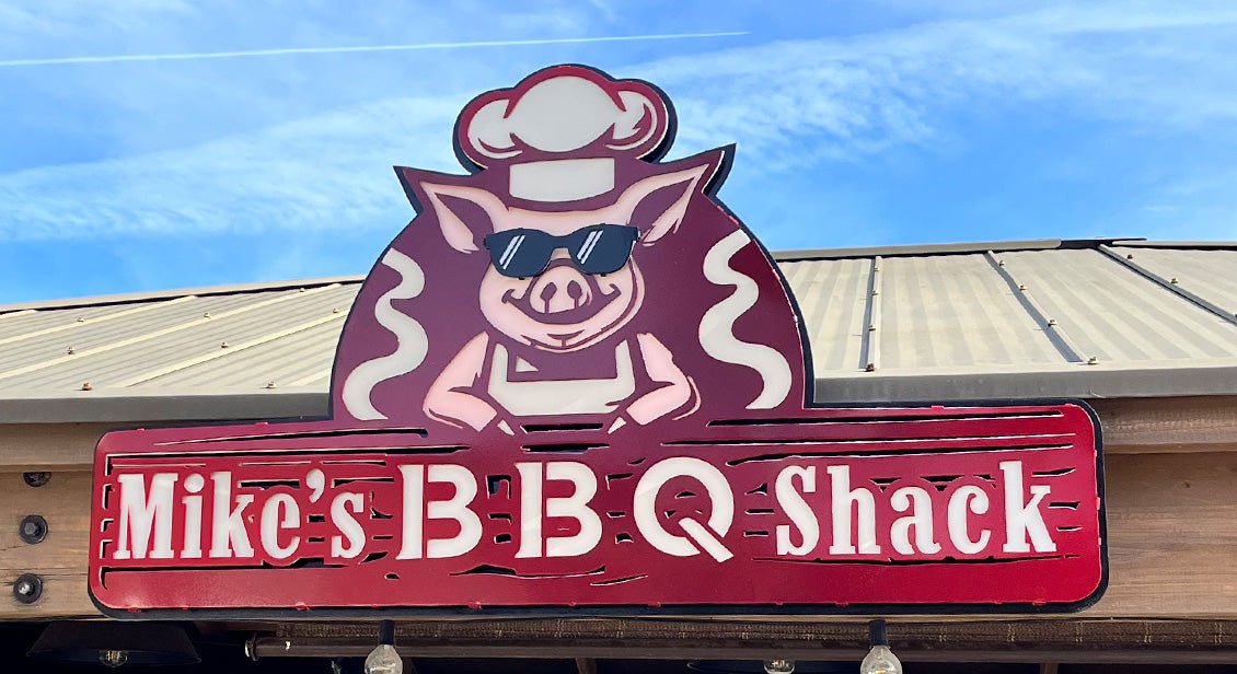 Custom dimensional metal BBQ Shack sign mounted above an outdoor kitchen