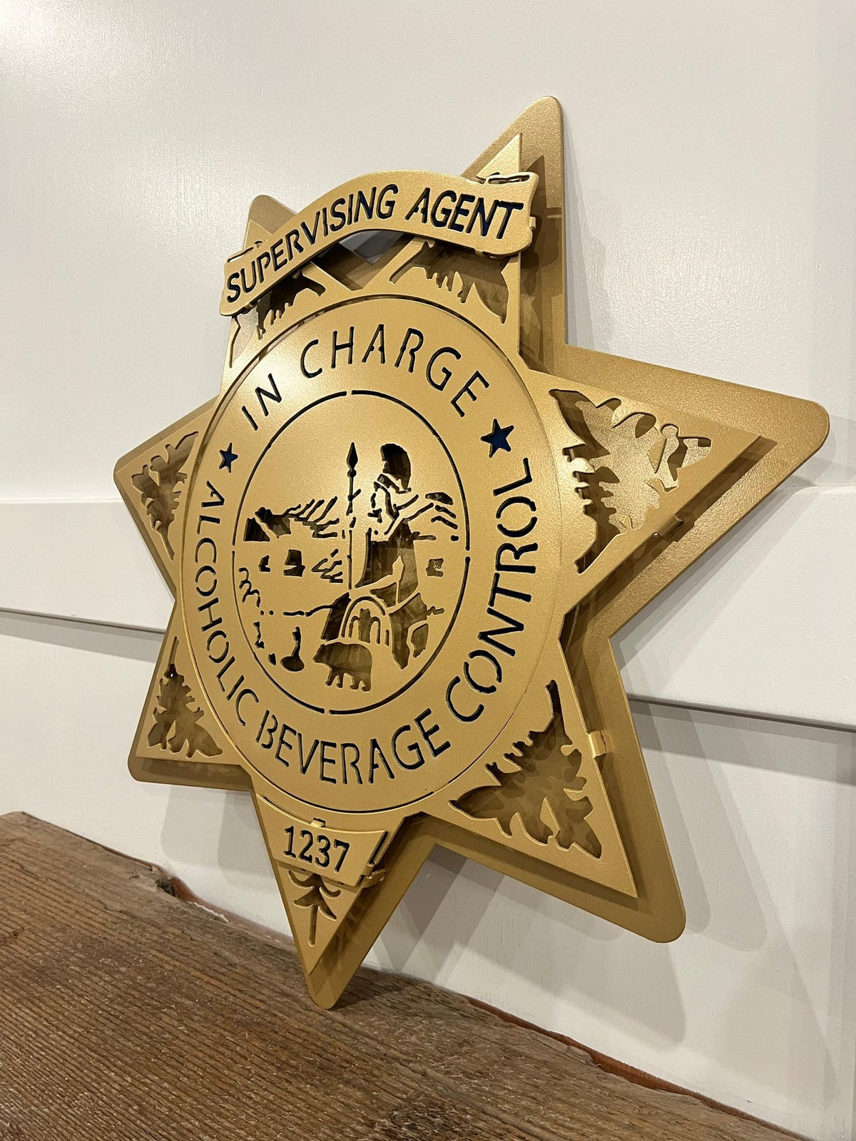 Angled view showing raised gold star layers, California ABC Investigations by IRONiNK.