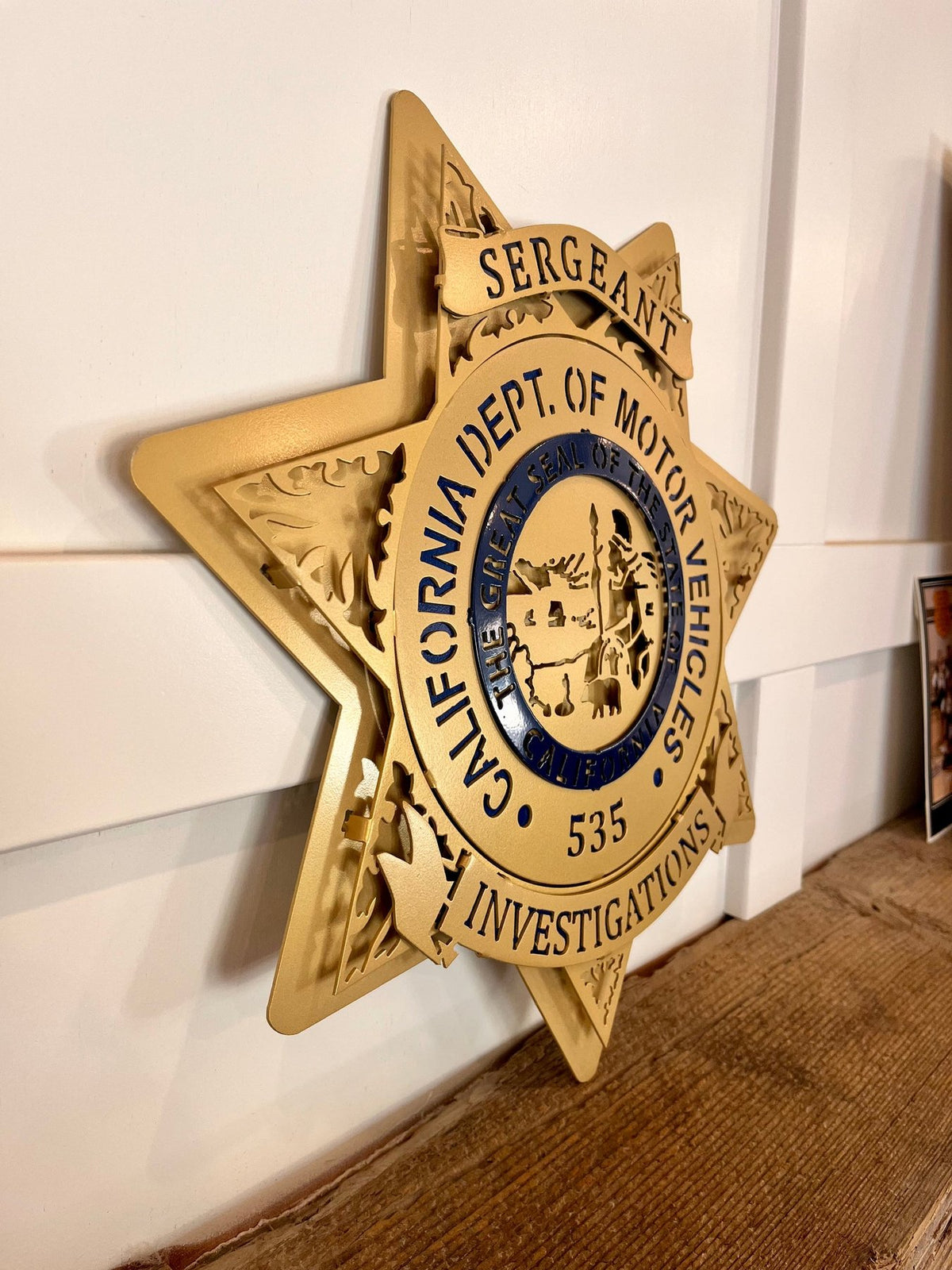 Gold sergeant star on a wooden shelf, California DMV Investigations by IRONiNK.