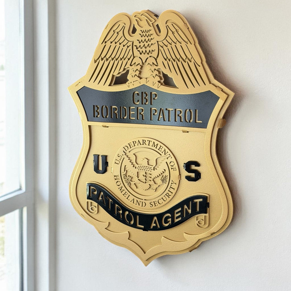 Gold Border Patrol badge displayed beside a window, CBP U.S. Border Patrol Custom Metal Badge Sign by IRONiNK.
