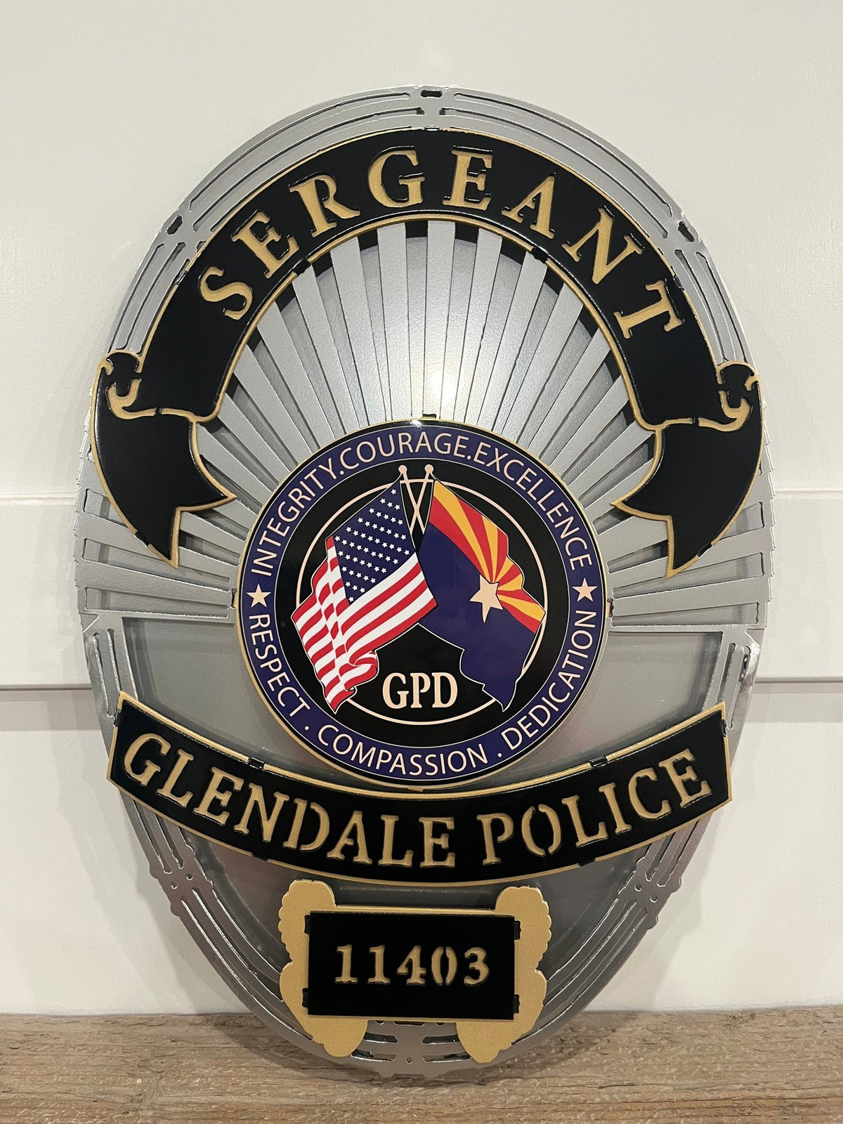 Silver and black sergeant badge on a wooden shelf, Glendale Police Department (AZ) by IRONiNK.