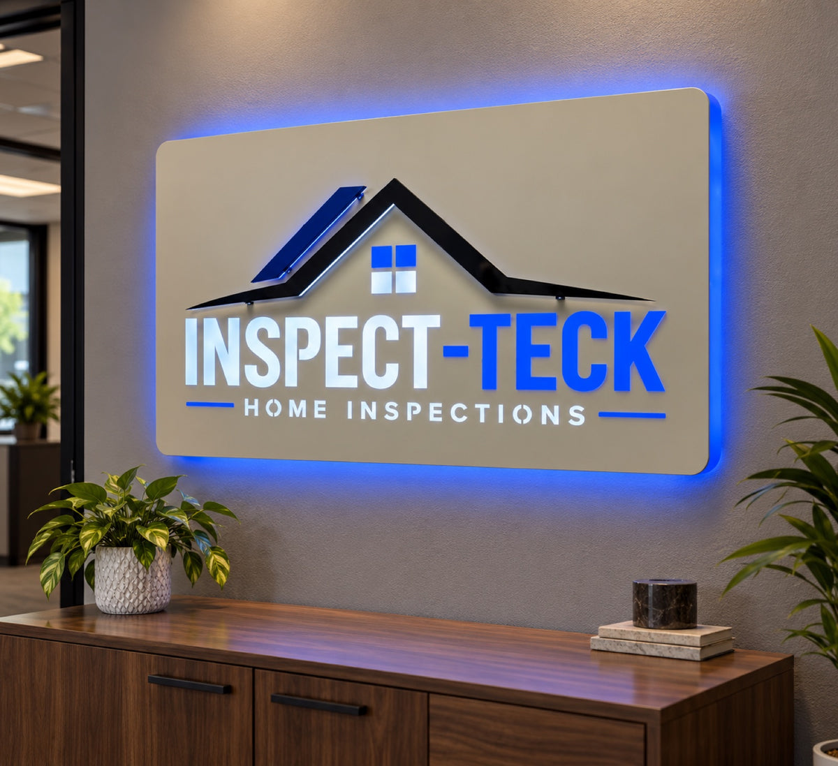 Inspect-Teck Home Inspections illuminated office sign with blue backlighting, a raised roofline logo and layered lettering on a gray wall