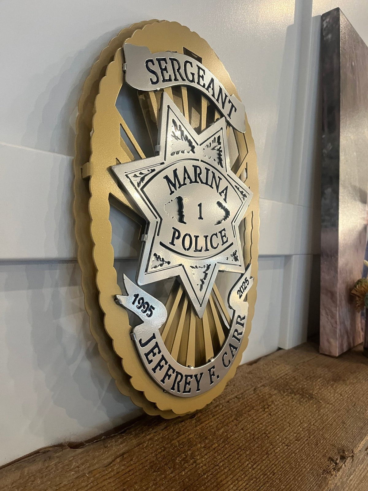 Gold and silver sergeant badge on a wooden shelf, Marina Police Department by IRONiNK.