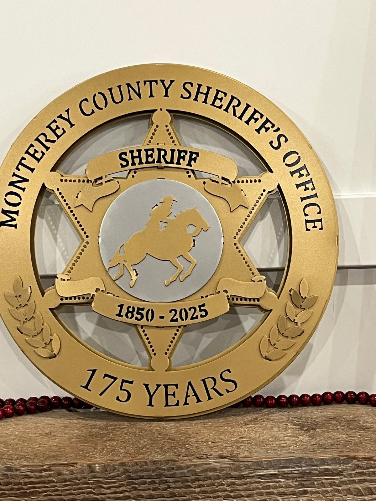 Anniversary sign displayed on a wooden shelf, Monterey County Sheriff Star by IRONiNK.