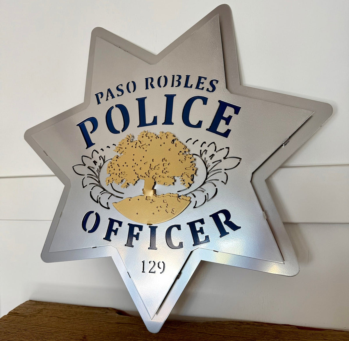 Silver police star on a wooden shelf, Paso Robles Police Badge by IRONiNK.