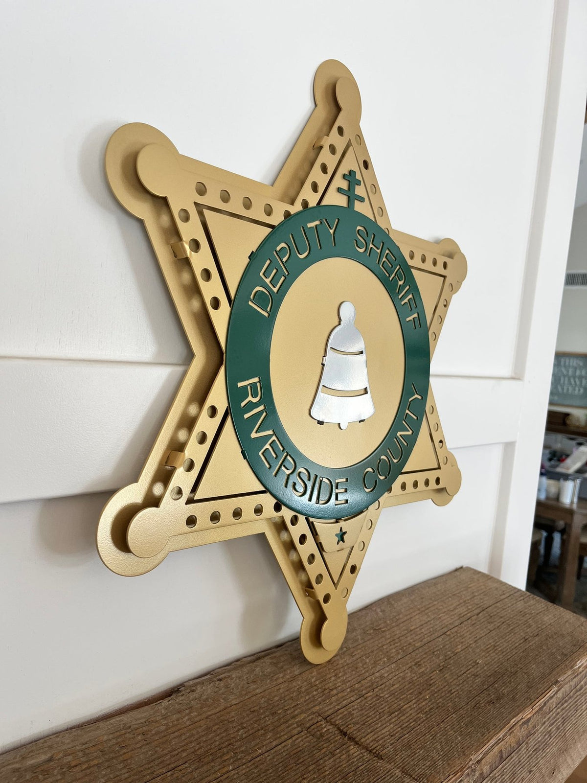 Gold and green sheriff star on a wooden shelf, Riverside County Sheriff Star by IRONiNK.