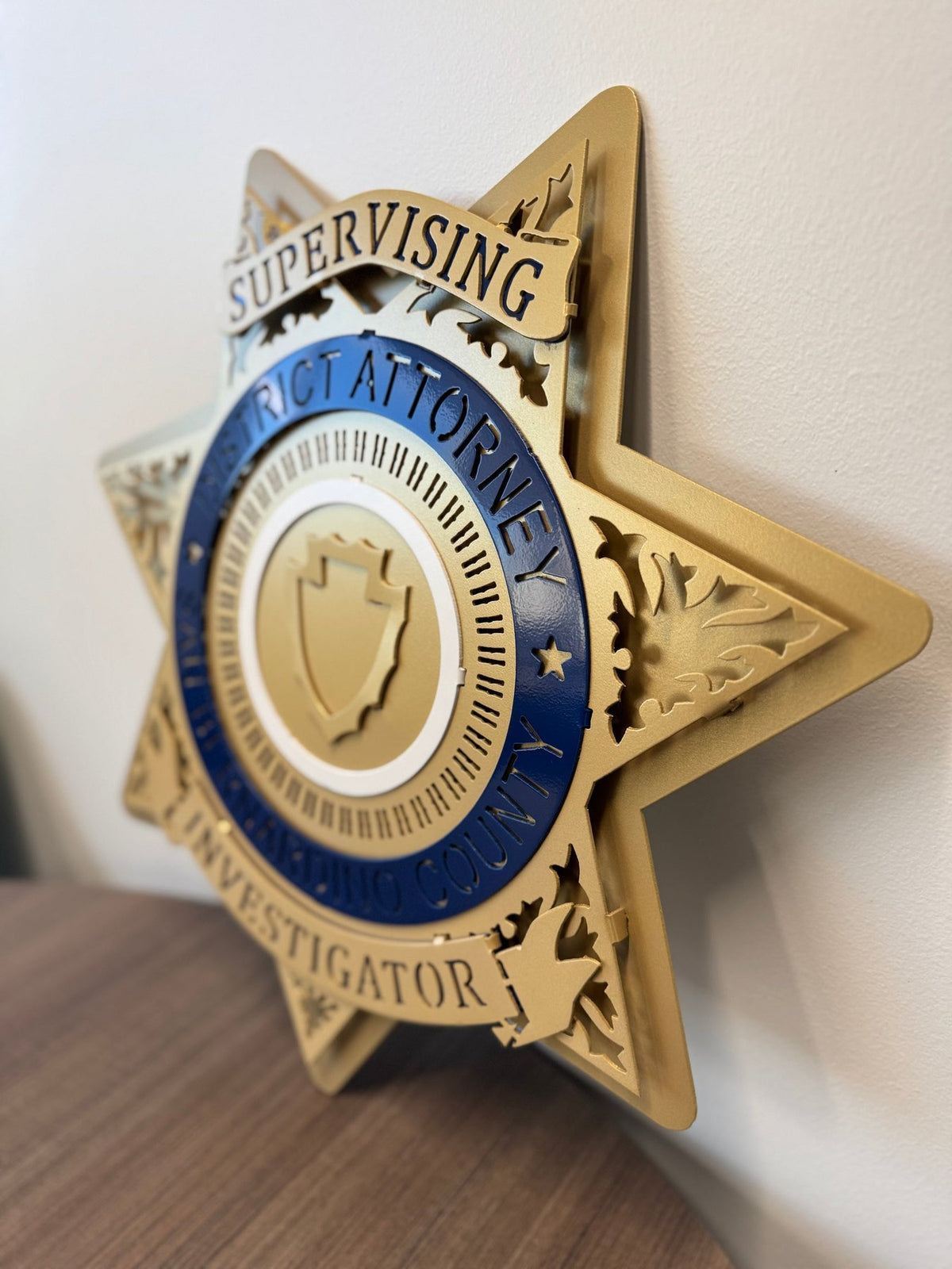 Gold supervising investigator star on a wooden shelf, San Bernardino County DA Star by IRONiNK.