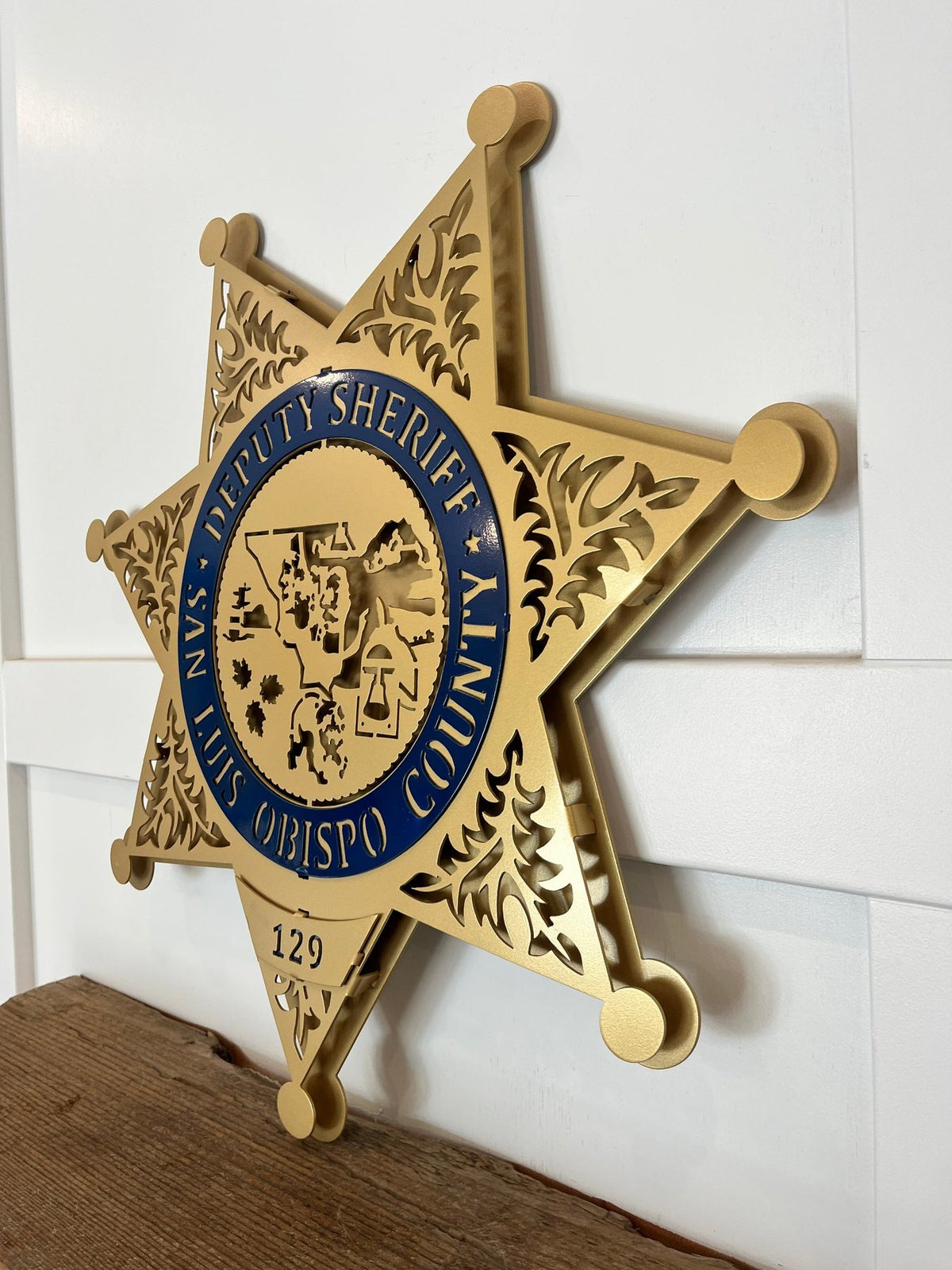 Gold sheriff star on a wooden shelf, San Luis Obispo County Sheriff Star by IRONiNK.