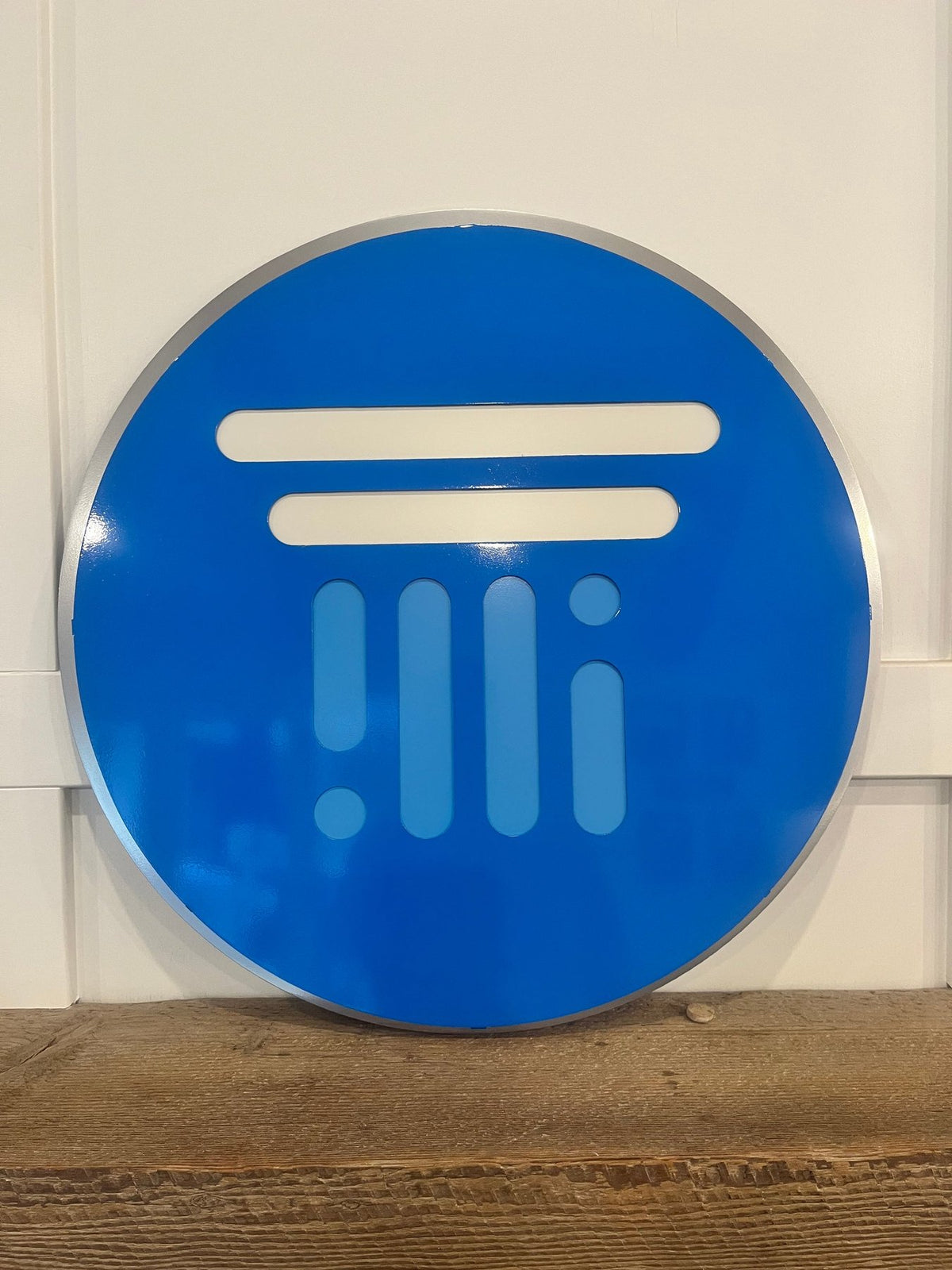Blue and silver logo on a wooden shelf, Tranquility AI by IRONiNK.