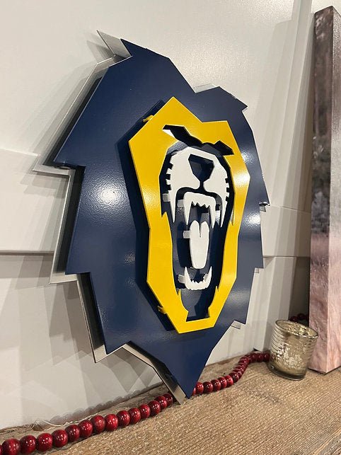 Navy and gold lion emblem on a wooden shelf, Vanguard University Lion by IRONiNK.